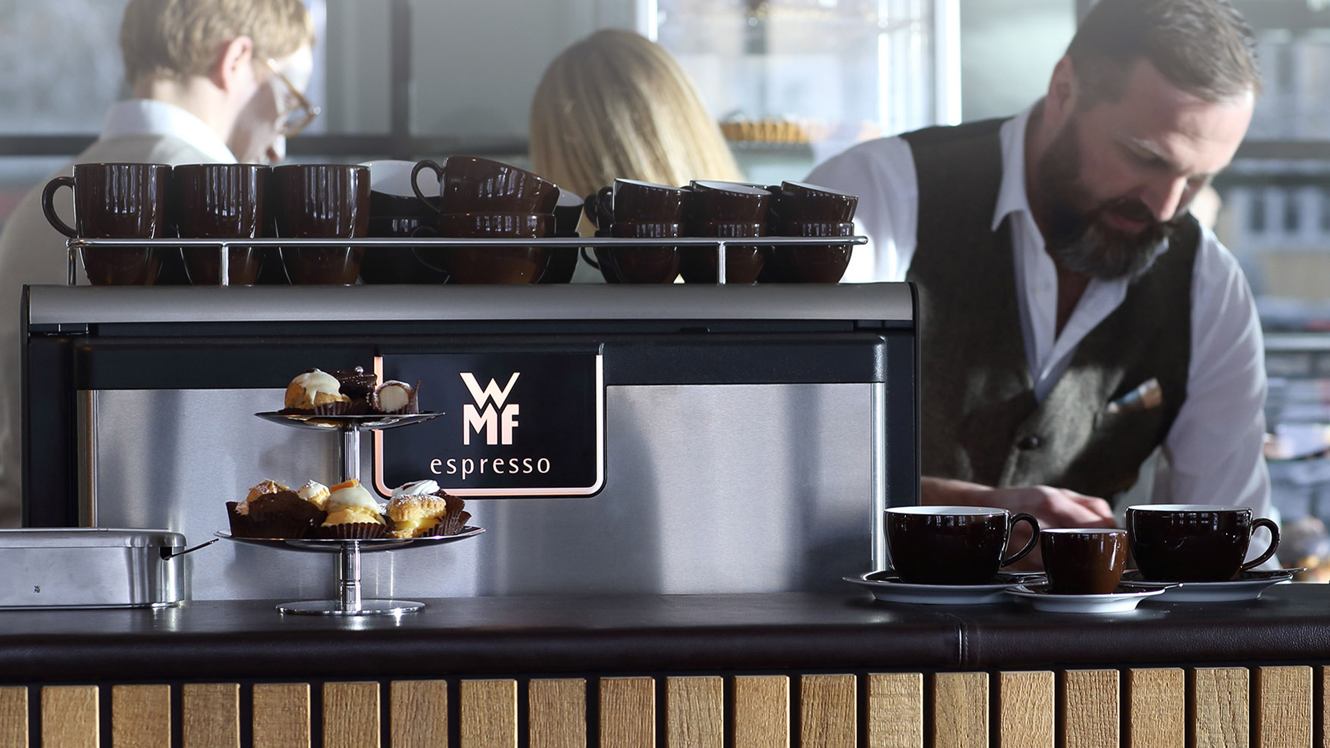 A barista serves coffee prepared with WMF espresso, a semi-automatic machine for gastronomy and catering. The coherent design was created by the design studio designship GmbH from Ulm. red dot award 2015 - best of the best - design award - designship GmbH - product design - industrial design - interface design - iF world design index - Top 25 Industry - Top 100 design studios worldwide - we love design
